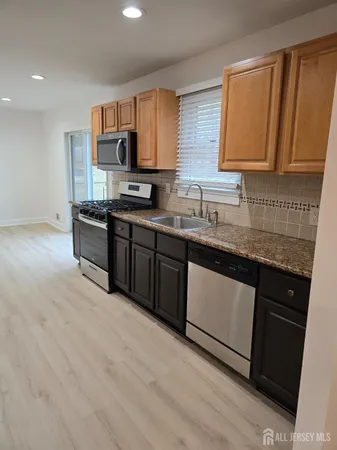 a kitchen with stainless steel appliances granite countertop a sink stove and cabinets