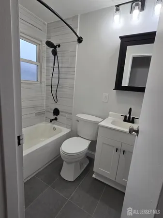 a bathroom with a toilet sink vanity tub and shower