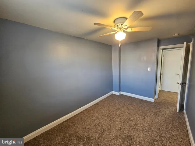 an empty room with a fan and a fan