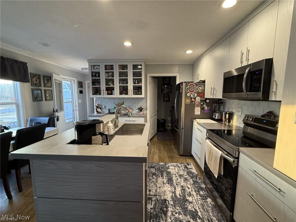 10252 Wellman Road, Unit 19 Streetsboro, OH 44241 - Photo 2 of 12 Kitchen featuring newer custom cabinetry, Corian countertops, center island and stainless steel appliances and recessed lighting