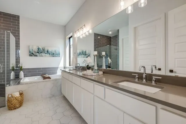 a bathroom with double vanity sinks and a bathtub