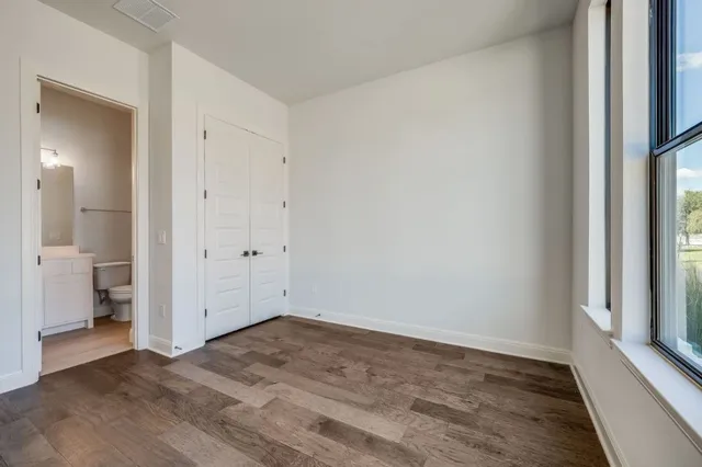 a view of empty room with wooden floor