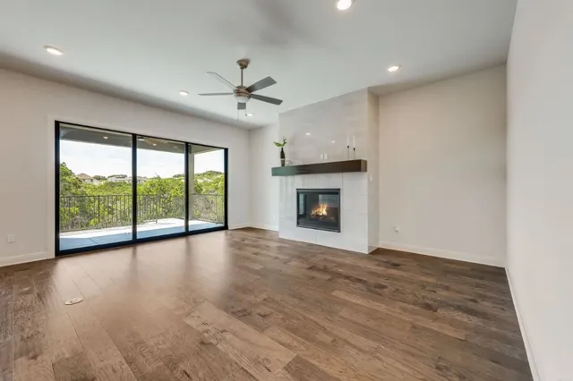a view of empty room with wooden floor and fireplace
