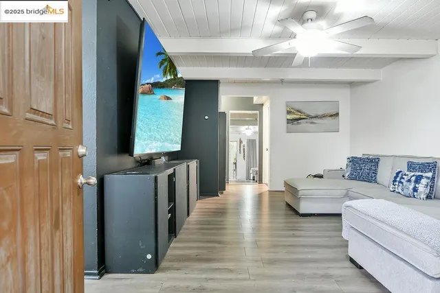a living room with furniture and a wooden floor