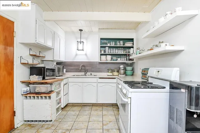 a kitchen with stainless steel appliances a stove a sink and cabinets
