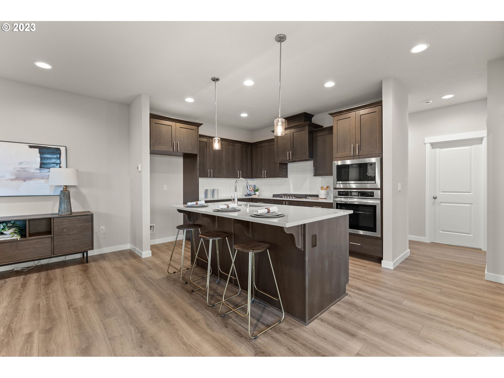 8823 North 3rd Circle Ridgefield, WA 98642 - Photo 8 of 41 a kitchen with stainless steel appliances kitchen island granite countertop a table chairs and a refrigerator
