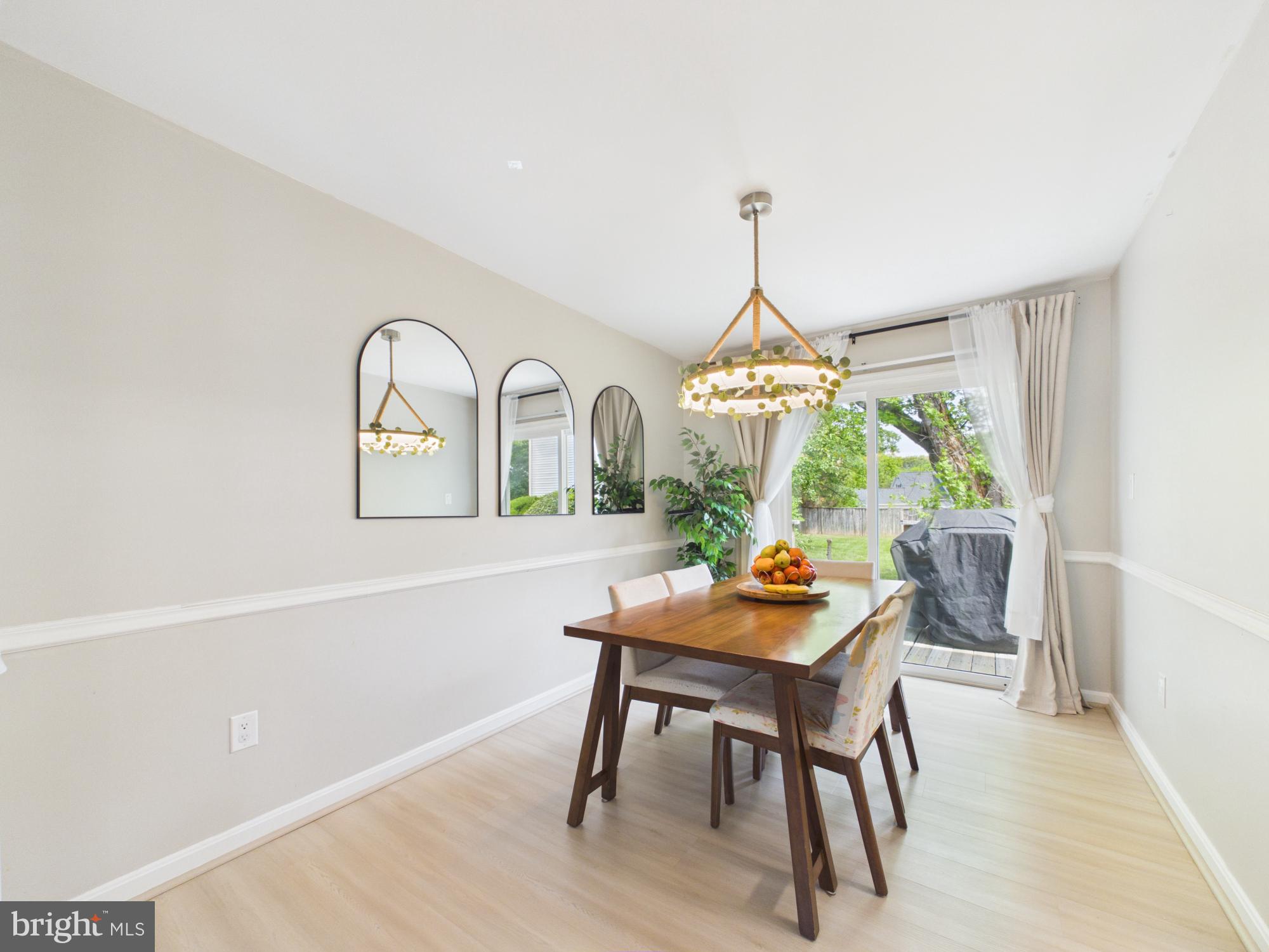 7606 Huntsman Court Clinton, MD 20735 - Photo 13 of 40 a dining room with furniture a chandelier and wooden floor