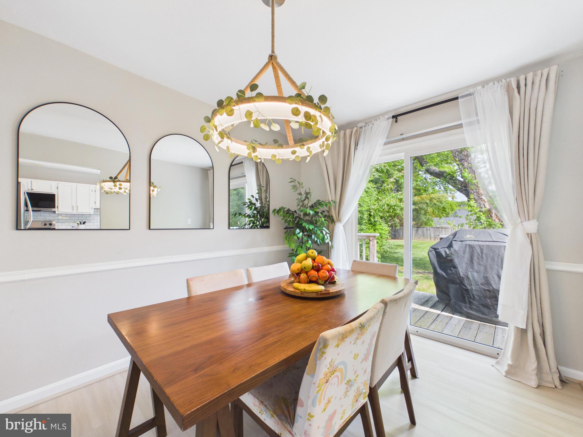 7606 Huntsman Court Clinton, MD 20735 - Photo 15 of 40 a dining room with furniture a chandelier and wooden floor