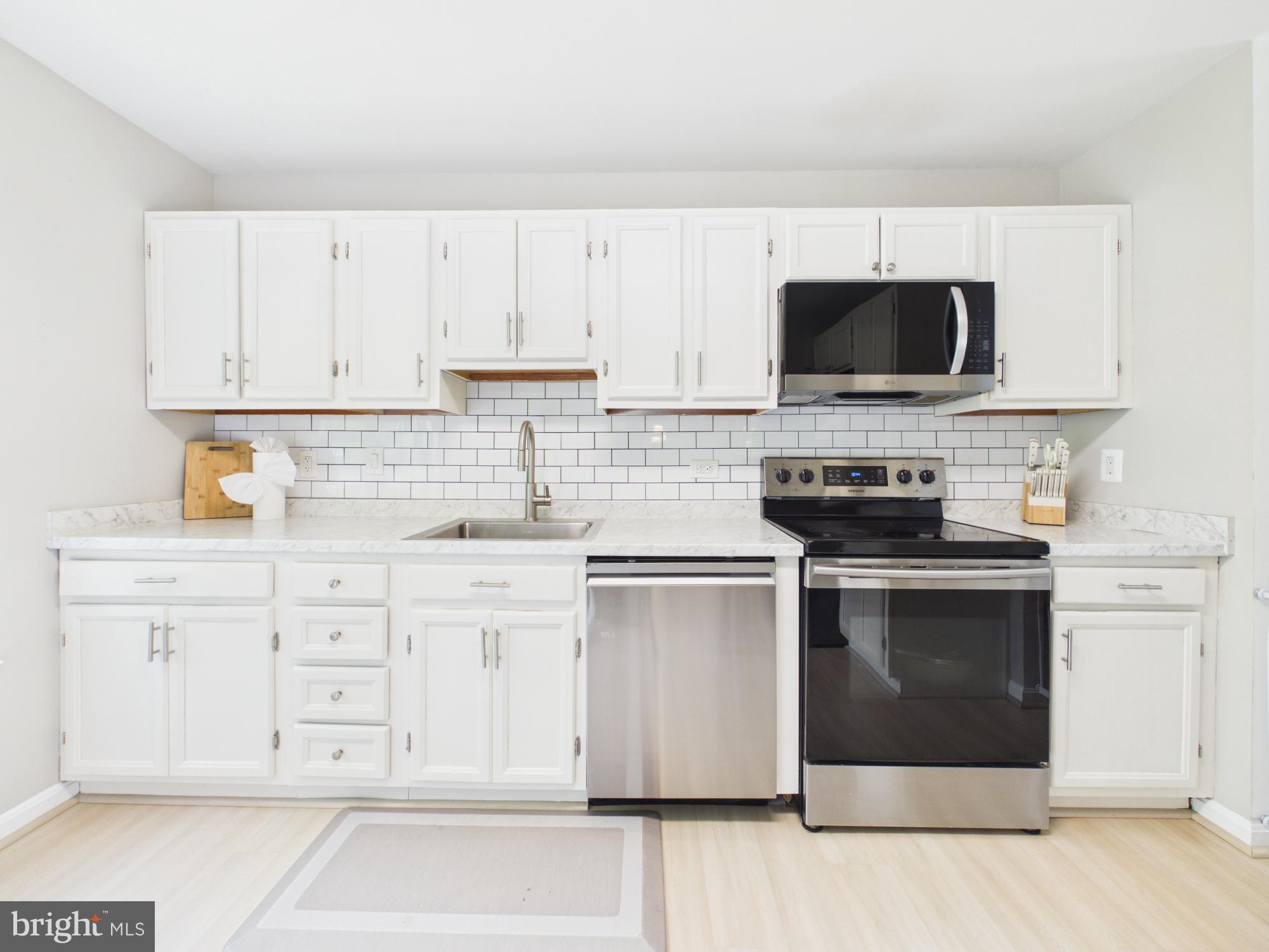 7606 Huntsman Court Clinton, MD 20735 - Photo 16 of 40 a kitchen with white cabinets stainless steel appliances and sink