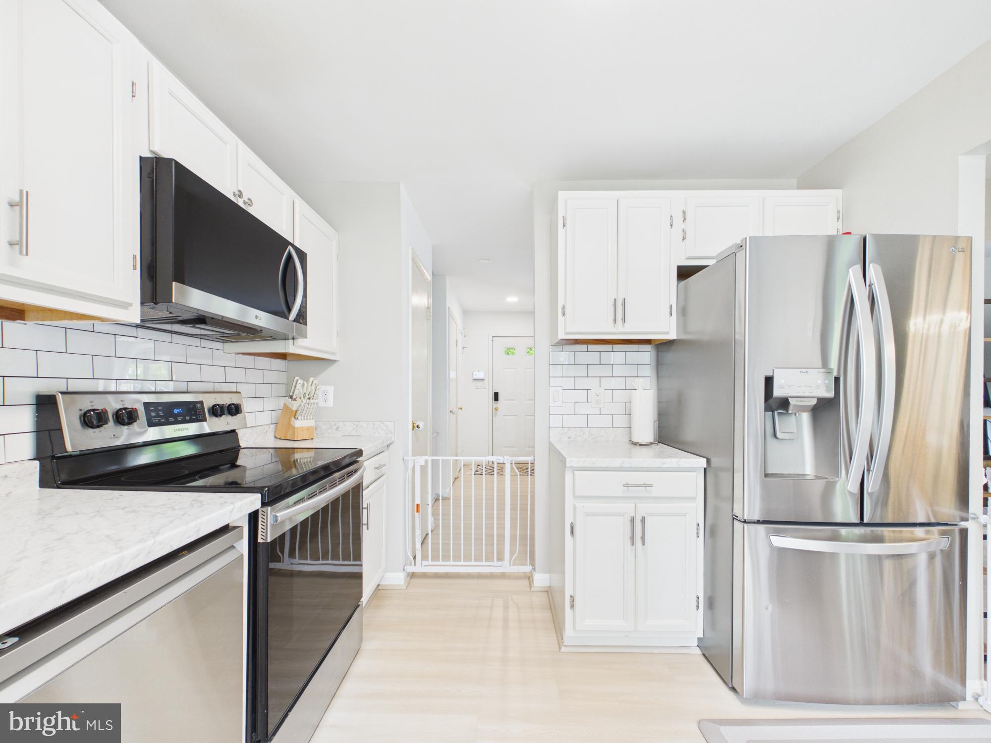 7606 Huntsman Court Clinton, MD 20735 - Photo 18 of 40 a kitchen with stainless steel appliances a refrigerator stove and microwave