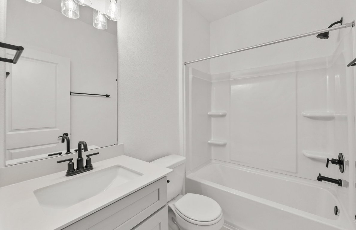 482 Kapok Street Buda, TX 78610 - Photo 14 of 22 a bathroom with a sink a toilet and a bathtub