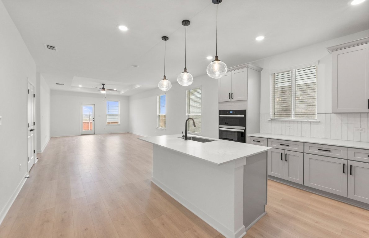 482 Kapok Street Buda, TX 78610 - Photo 4 of 22 a large kitchen with stainless steel appliances kitchen island a large island in the center