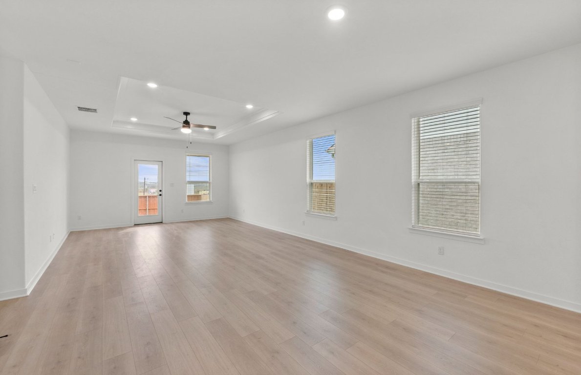 482 Kapok Street Buda, TX 78610 - Photo 8 of 22 an empty room with wooden floor and windows
