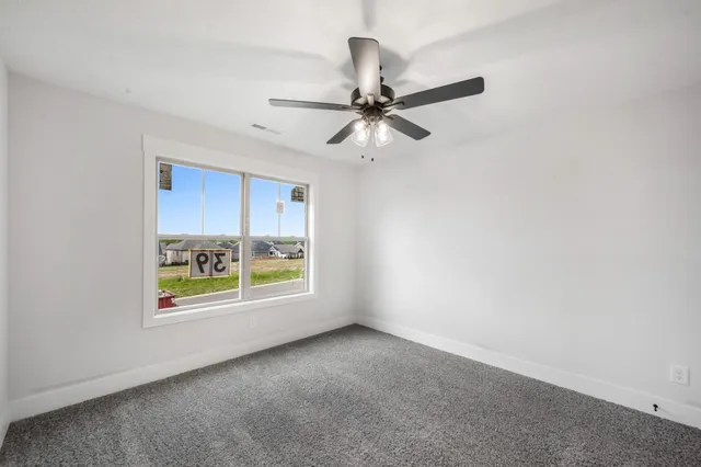 an empty room with a window and a fan