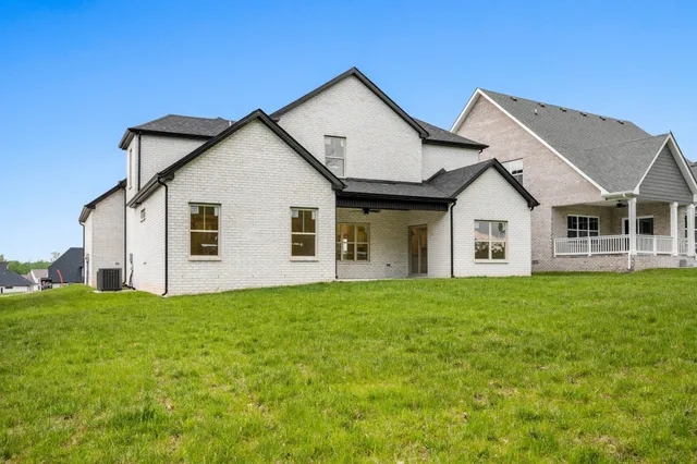 a view of a house with a yard and large trees