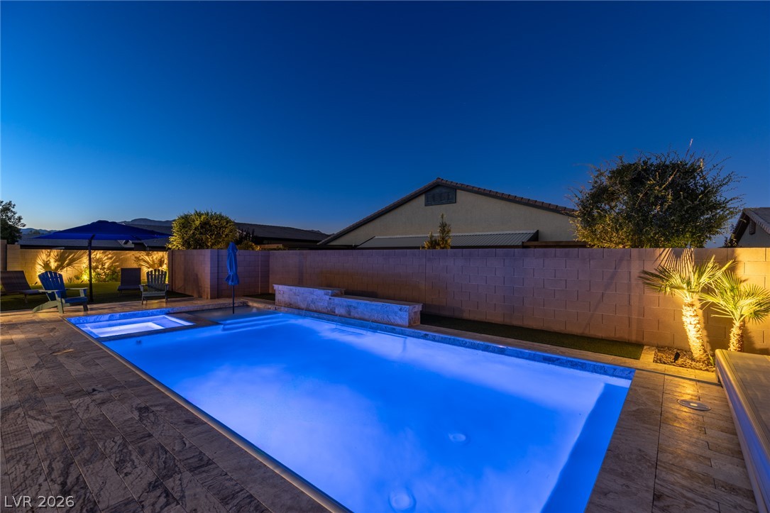 7036 Arabian Ridge Street Las Vegas, NV 89131 - Photo 55 of 64 Sparkling pool and spa with an automated cover, cantilever umbrella, and safety fence perfect for escaping those hot summer days.