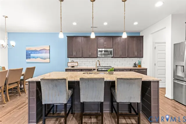 a large kitchen with kitchen island a sink stove and cabinets