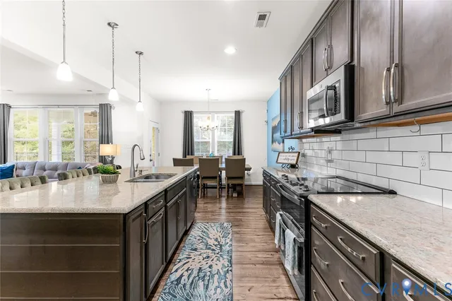 a kitchen with granite countertop a sink stove and cabinets