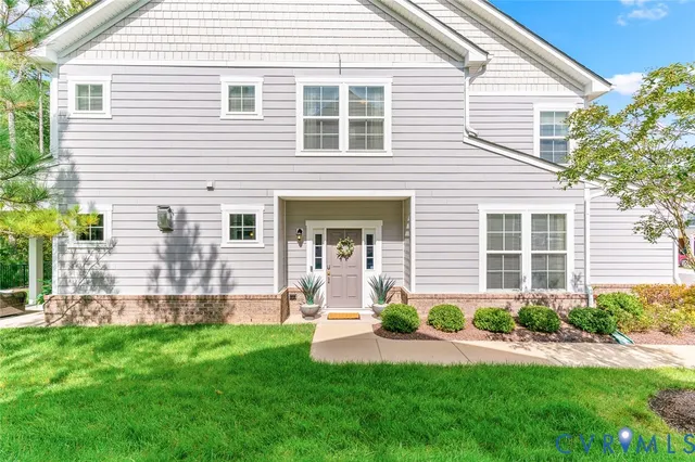 a front view of a house with a yard and potted plants