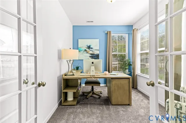 a view of a workspace with furniture and a window