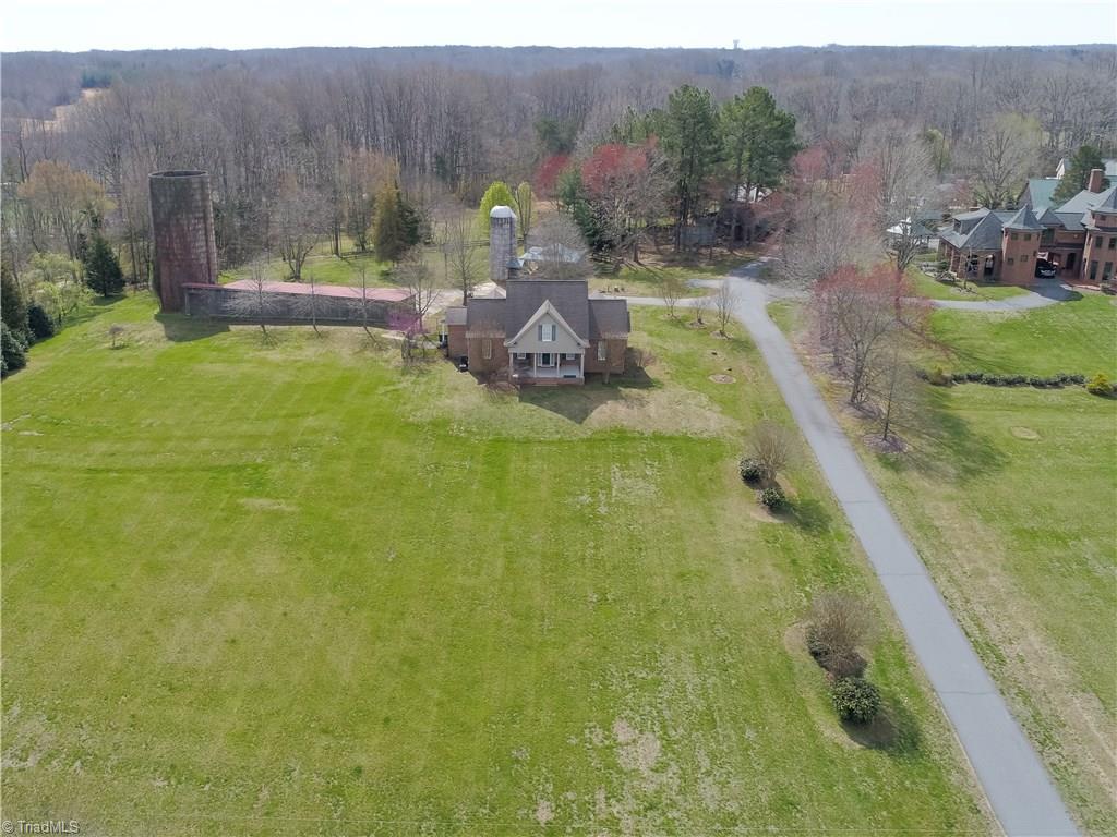 7857 Alcorn Road Oak Ridge, NC 27310 - Photo 4 of 28 Guest House has 2700 SF with Master BR on the main level, large Kitchen & dining area with vaulted ceilings and a window wall, Great room with gas log fireplace that adjoins a Sunroom and 2nd story has 2 BRs,1 bath & loft.
