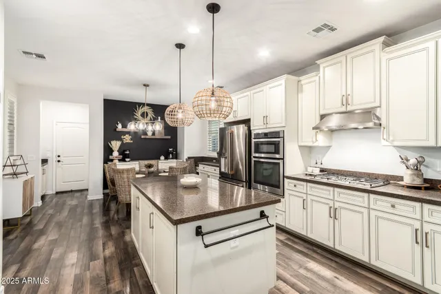 a kitchen with kitchen island a counter space a sink appliances and cabinets