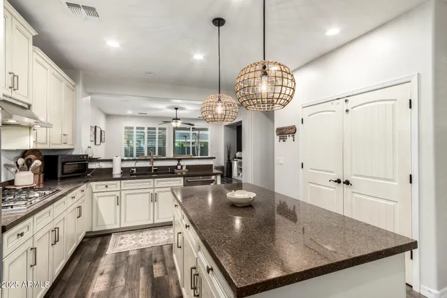 a kitchen with stainless steel appliances granite countertop a sink a stove and cabinets