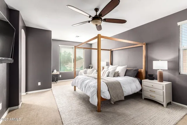 a bedroom with a bed and a ceiling fan