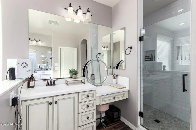 a bathroom with a double vanity sink mirror and shower
