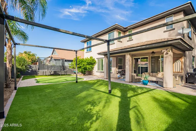 a view of a house with a yard patio and swimming pool