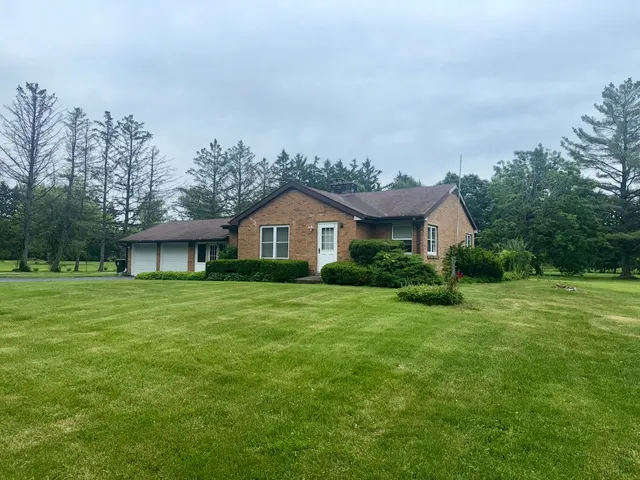 a front view of a house with a yard and trees