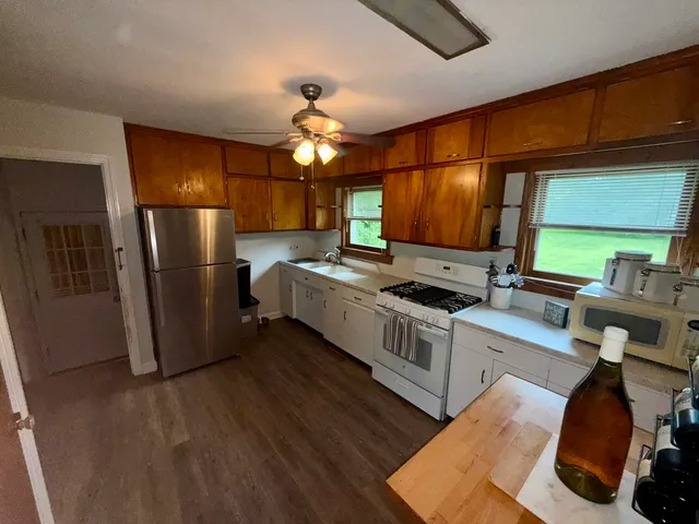 a kitchen with stainless steel appliances granite countertop a refrigerator a sink dishwasher a stove and a refrigerator