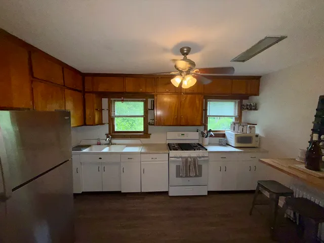 a kitchen with a sink stainless steel appliances cabinets and a window