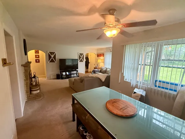 a dining room with furniture and a large window
