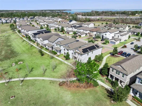 an aerial view of residential houses with outdoor space and trees
