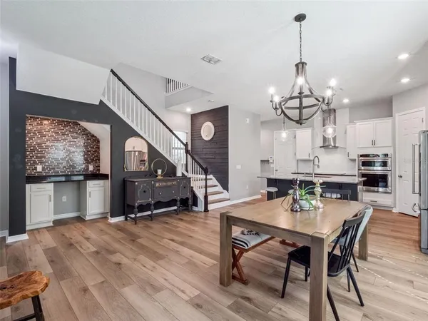 a view of a dining room with furniture a rug and wooden floor