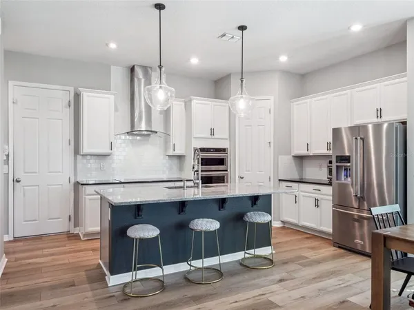 a kitchen with stainless steel appliances granite countertop a sink a stove and a refrigerator