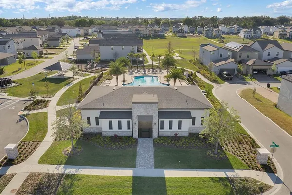 a view of a swimming pool with a lawn chairs under palm trees