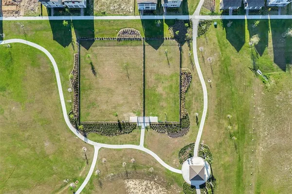 an aerial view of residential houses with outdoor space and trees