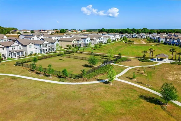 an aerial view of residential houses with outdoor space and trees