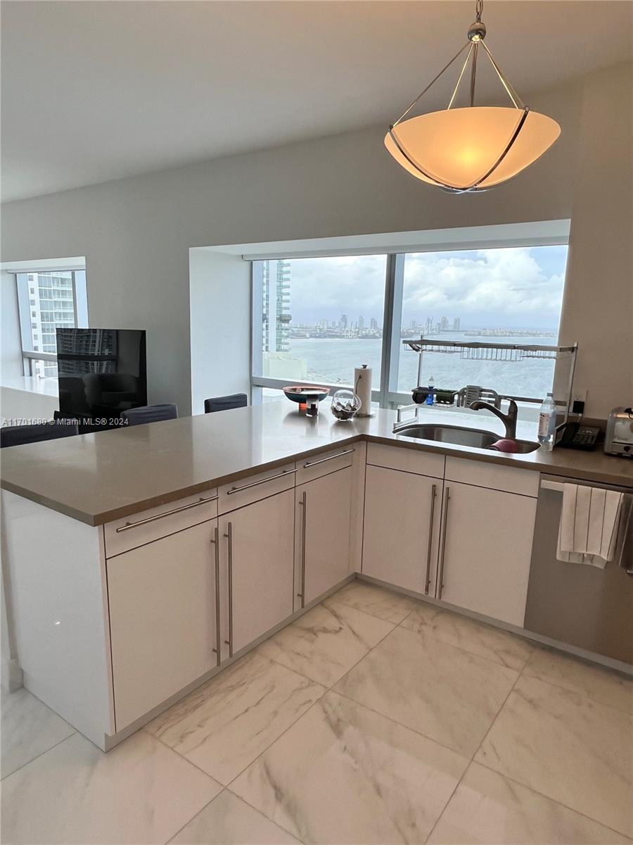 1435 Brickell Avenue, Unit 3307 Miami, FL 33131 - Photo 39 of 76 a kitchen with stainless steel appliances a sink stove and window