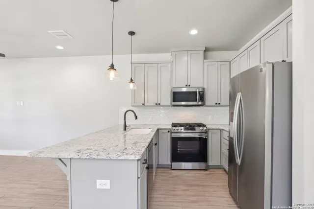 a kitchen with kitchen island a sink stainless steel appliances and cabinets