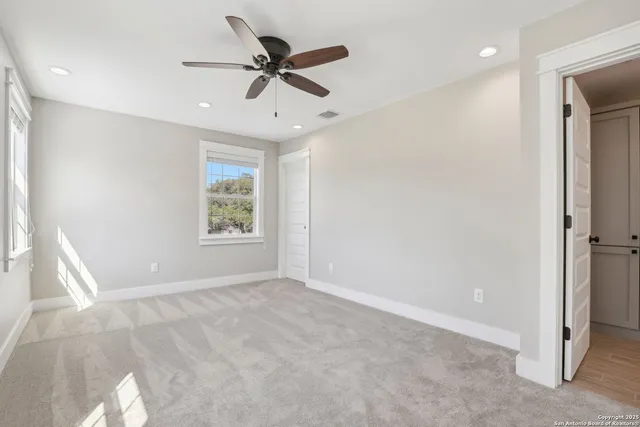 an empty room with windows and fan