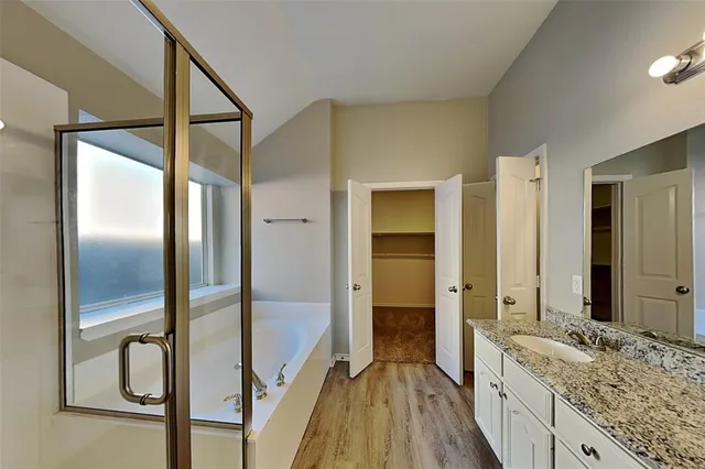 a spacious bathroom with a granite countertop sink mirror and shower
