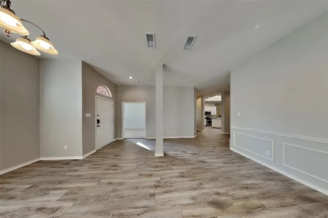 a view of a big room with wooden floor and windows
