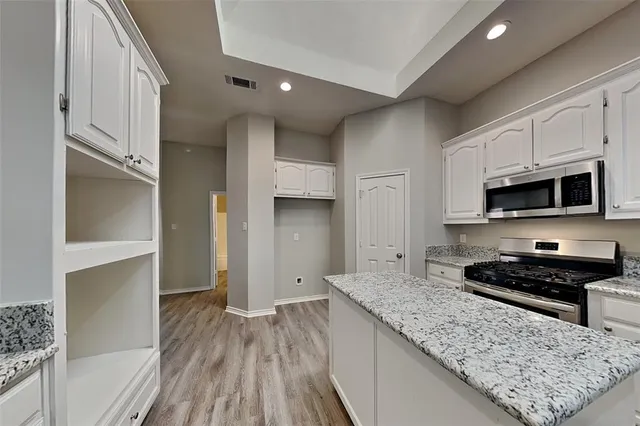 a kitchen with stainless steel appliances granite countertop a stove and a sink