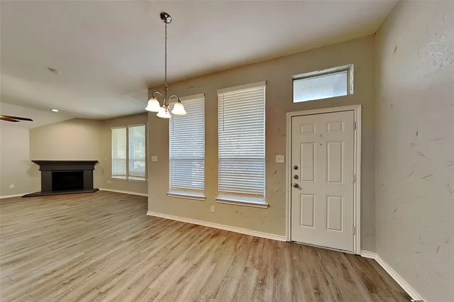 a view of a room with wooden floor fireplace and window