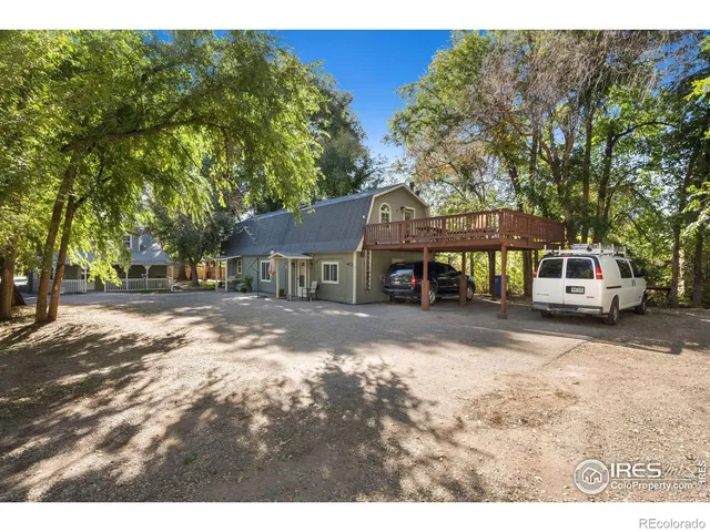 a view of a small house with wooden fence and trees