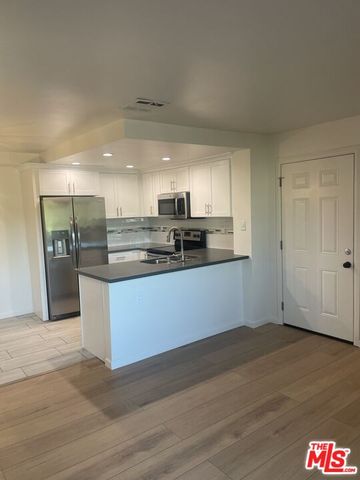 a kitchen with stainless steel appliances granite countertop a refrigerator and a stove