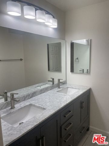 a bathroom with a granite countertop sink a large mirror and vanity